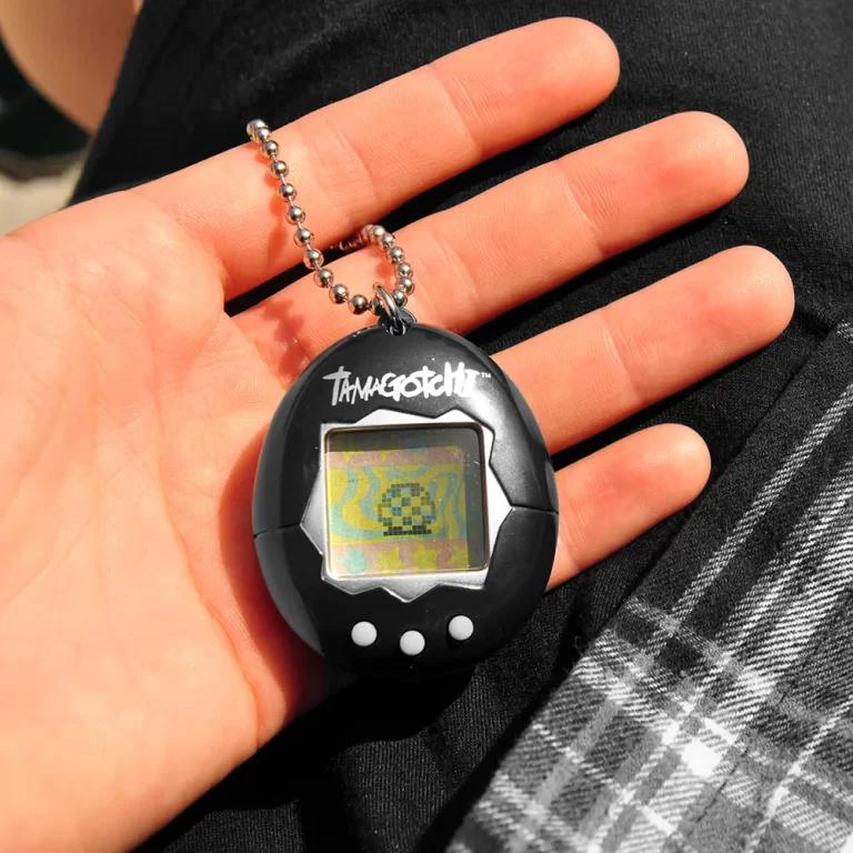 Mascota virtual negra en la palma de la mano de un niño